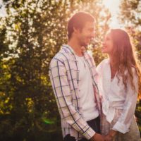 joli couple heureux se regardant au parc d'été