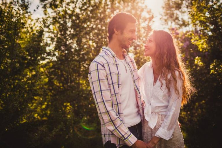 joli couple heureux se regardant au parc d'été