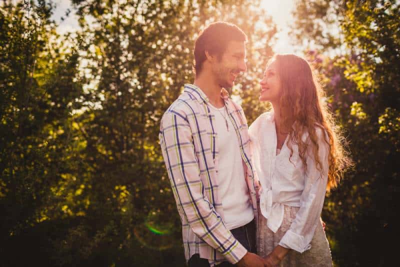 joli couple heureux se regardant au parc d'été