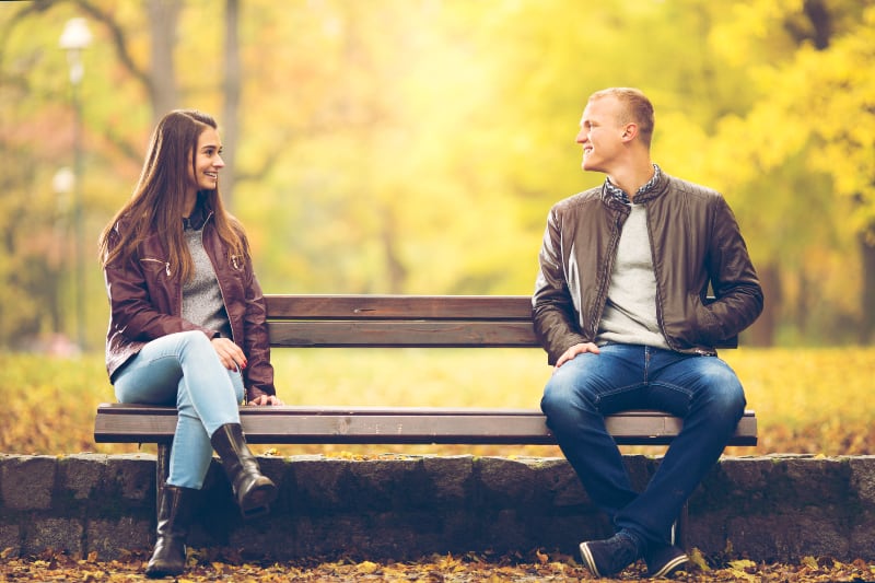 Jeune couple est assis sur un banc
