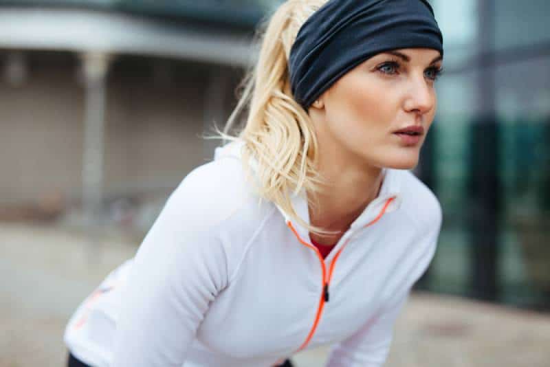 Jeune femme se penchant dans un équipement sportif
