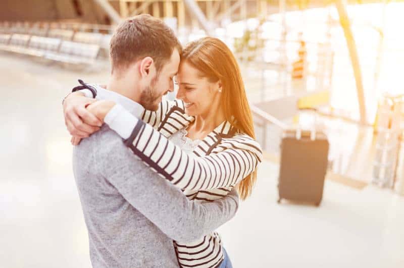 Un couple heureux s'embrasse à l'aéroport