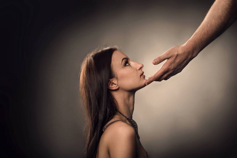 La main de l'homme touche le visage de la femme comme un harcèlement sexuel