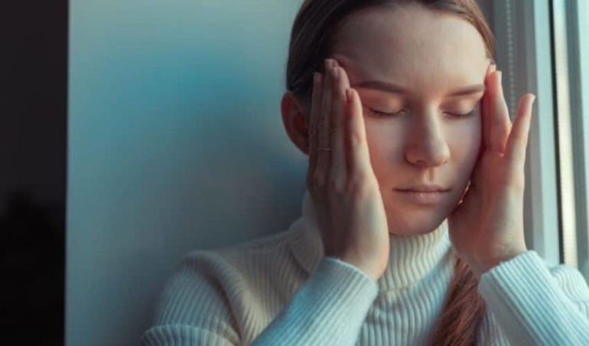 la femme tient ses tempes avec ses mains