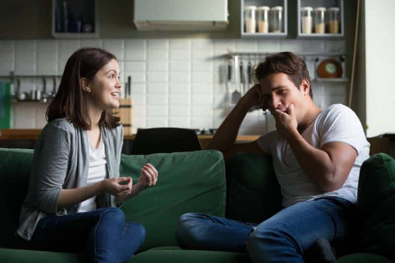 Le jeune homme baille et s'ennuie lorsqu'il écoute la femme excitée qui parle