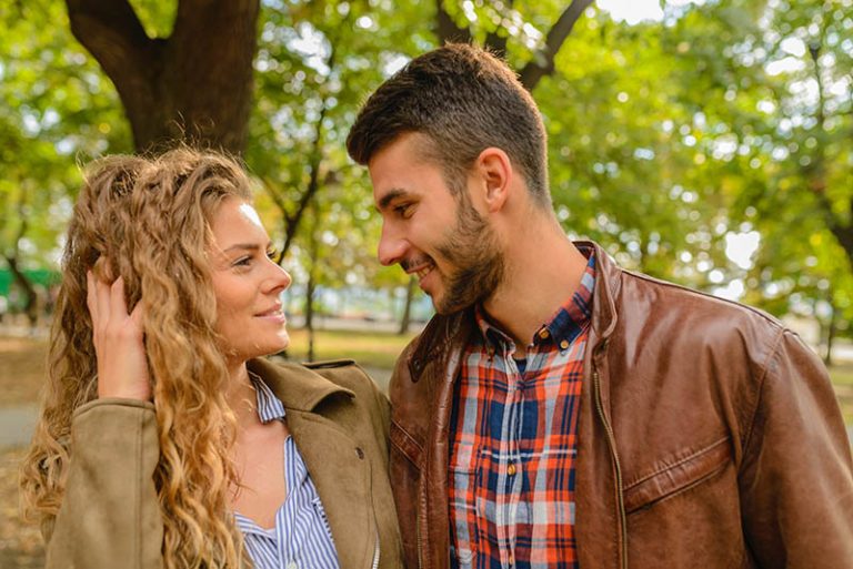 Un homme et une femme souriants se regardent dans les yeux