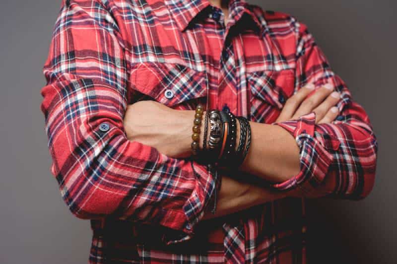 L'homme en chemise rouge portant des bracelets, style décontracté des accessoires pour hommes.