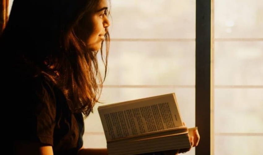une femme assise avec un livre a la main