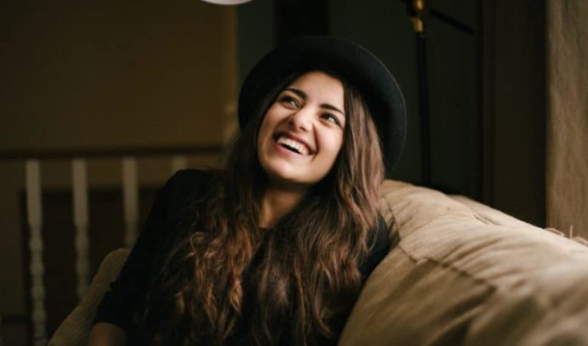 une femme brune avec un chapeau sur la tete