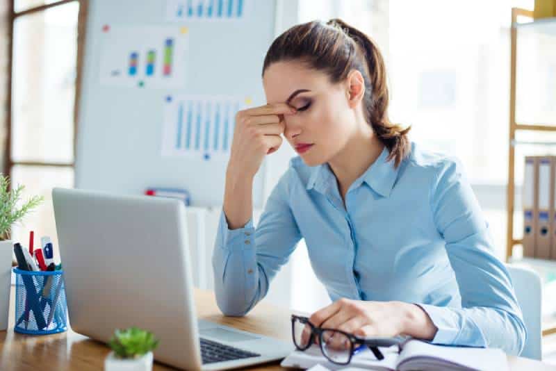 Portrait d'une femme d'affaires fatiguée qui a des maux de tête sur son lieu de travail