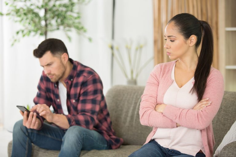 un bouton d'homme sur le téléphone d'une femme le regardant de côté