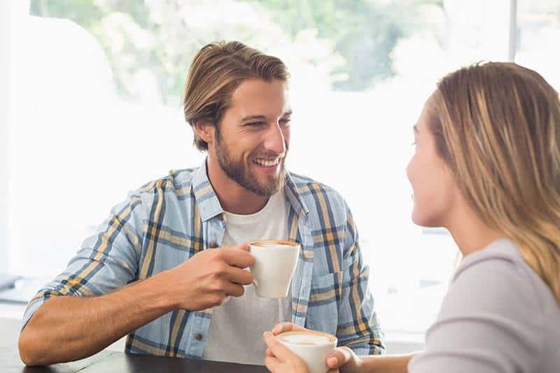 Un couple heureux discute en buvant un café