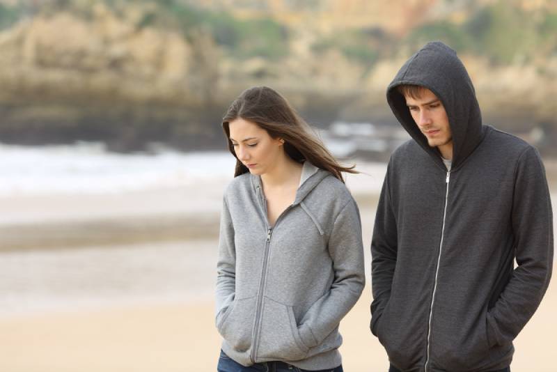 Un couple malheureux se promène sur la plage
