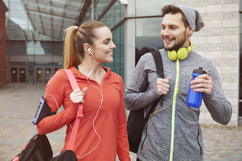 Un couple souriant se rend à la salle de sport