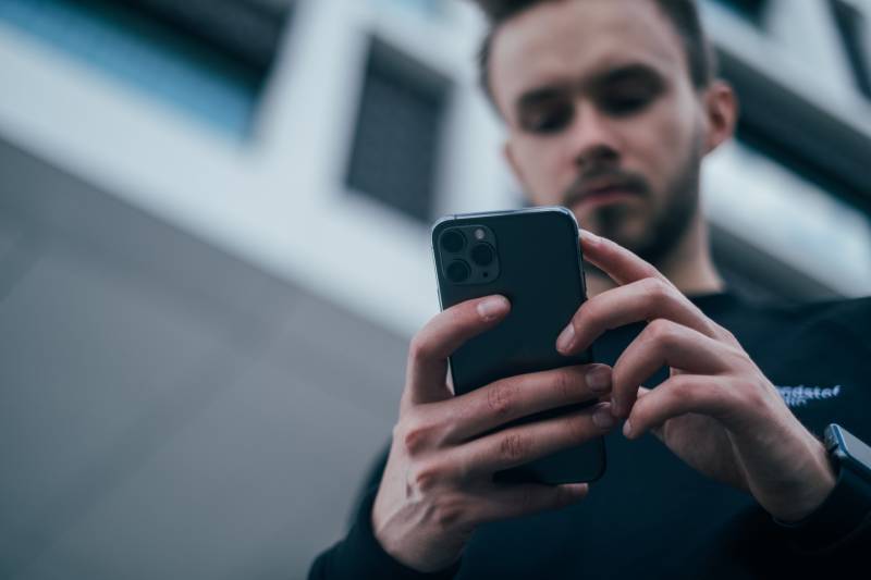 Un homme regarde le téléphone à l'extérieur