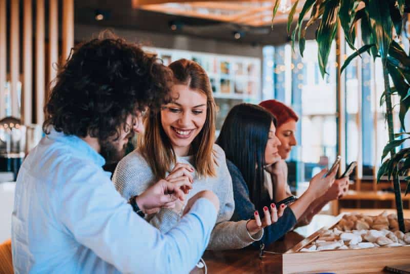 Un jeune homme et une jeune femme souriants dans un café local