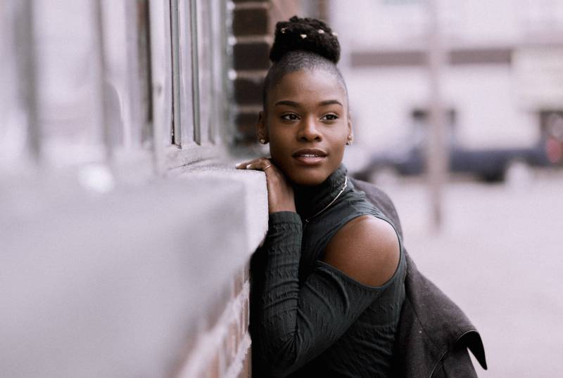Une femme appuyée contre le mur dans la rue