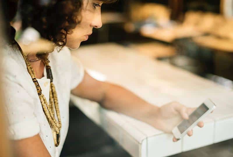 Une femme désespérée regarde son téléphone dans un café