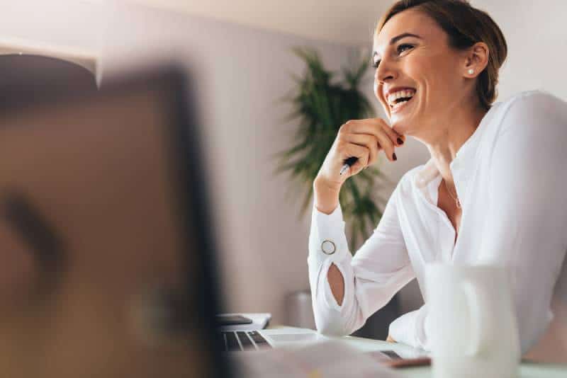Une femme souriante assise à son bureau