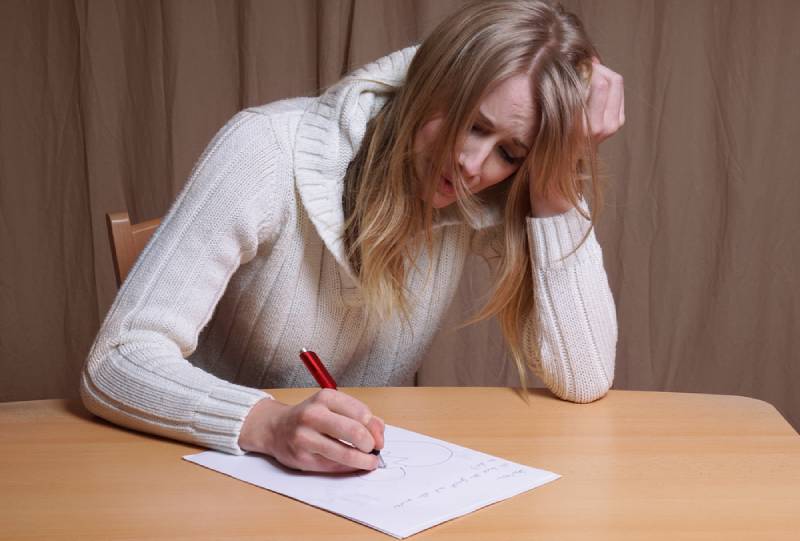 Une jeune femme en mal d'amour écrit une lettre avec le cœur brisé