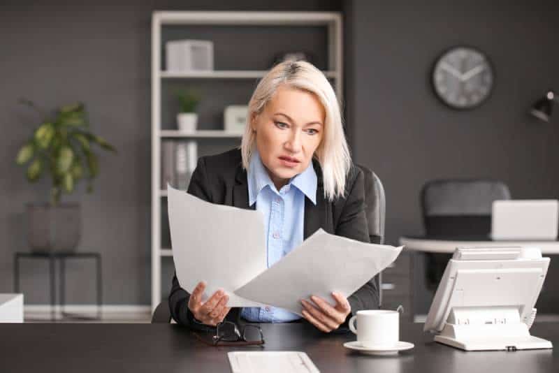Une triste femme d'âge mûr lit l'ordonnance de révocation de sa fonction