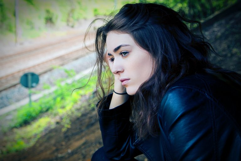 la femme est assise pensivement en appuyant sa main sur sa joue