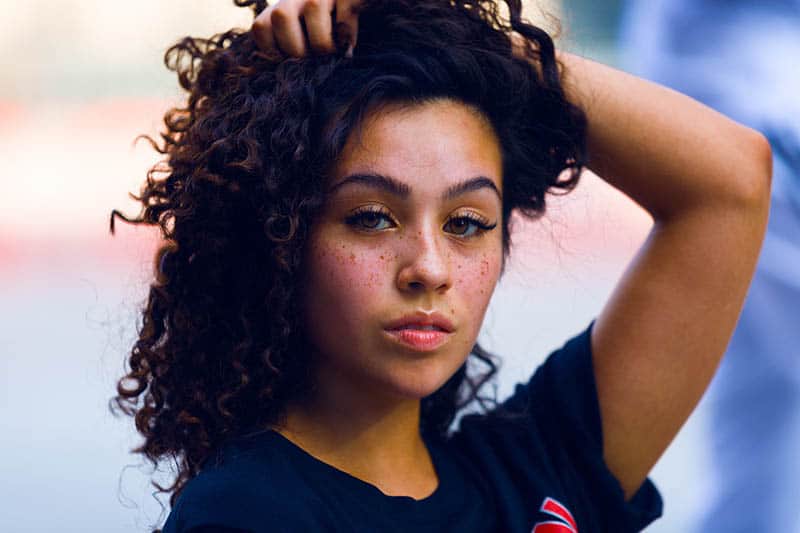 belle femme aux cheveux bouclés regardant la caméra