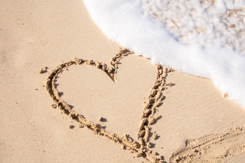 coeur sur le sable de la plage lavé par l'eau de mer