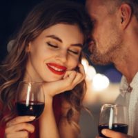 couple romantique avec des verres à vin rouges dans leurs mains