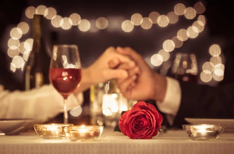 Un couple se tenant la main ayant une date de dîner romantique