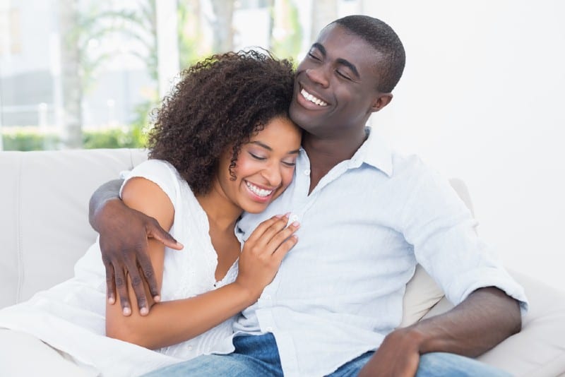 un couple s'embrasse sur le canapé