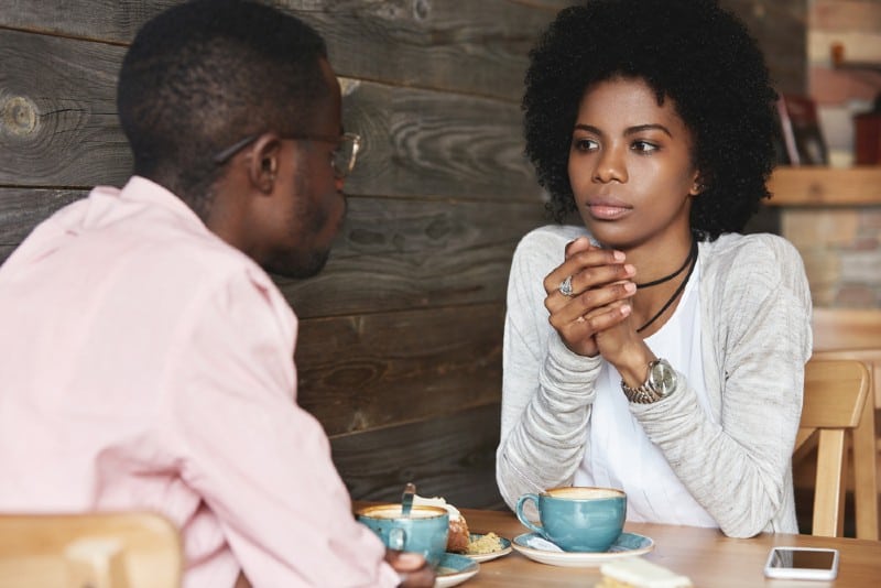 couple assis à une table devant l'autre