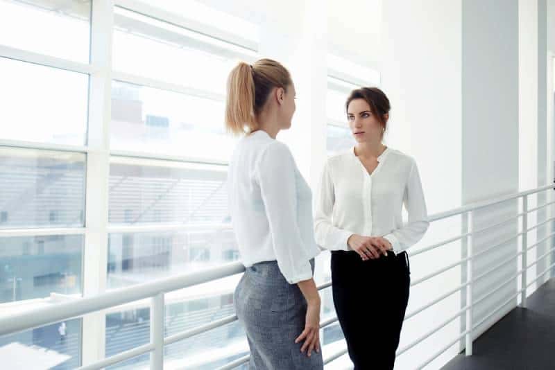 des femmes entrepreneurs parlent de quelque chose de personnel en se tenant près de la fenêtre de leur bureau