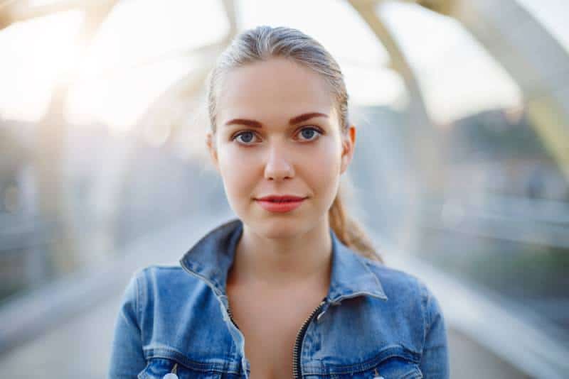 femme avec une chemise bleue, debout à l'extérieur
