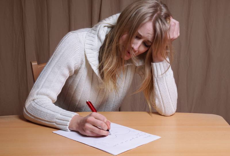 femme en pleurs qui écrit une lettre
