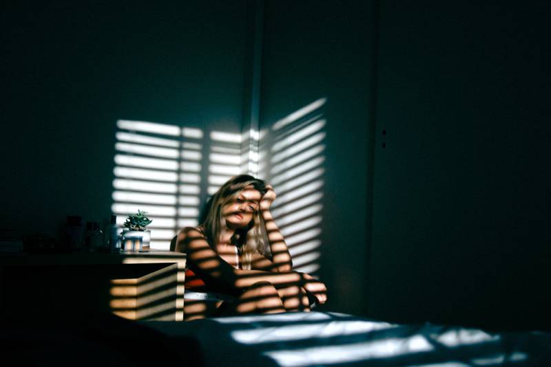 femme pensive assise à la maison