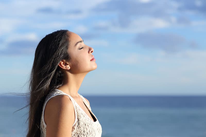 femme respirant profondément par la mer