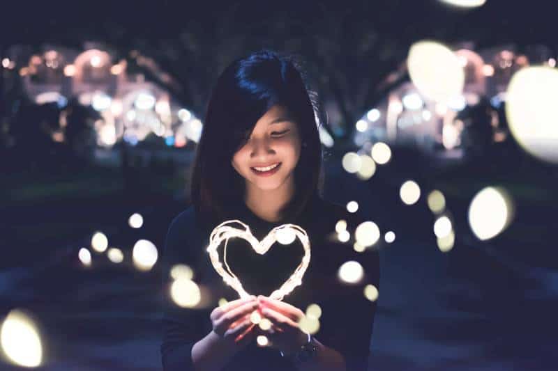 femme tenant une lampe en forme de coeur