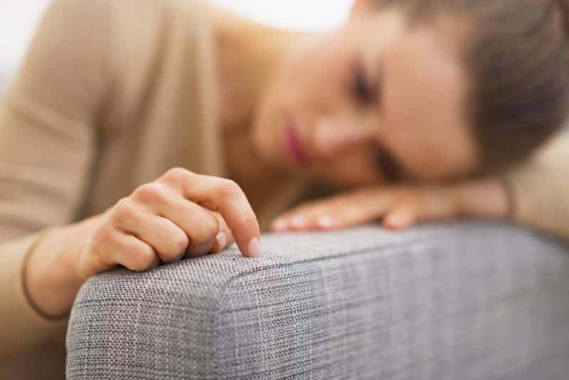femme triste allongée dans le salon et pensant