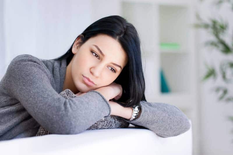 femme triste allongée sur le canapé du salon