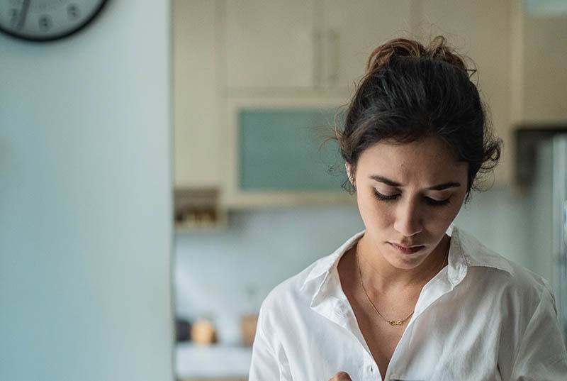 femme triste regardant en bas à la maison