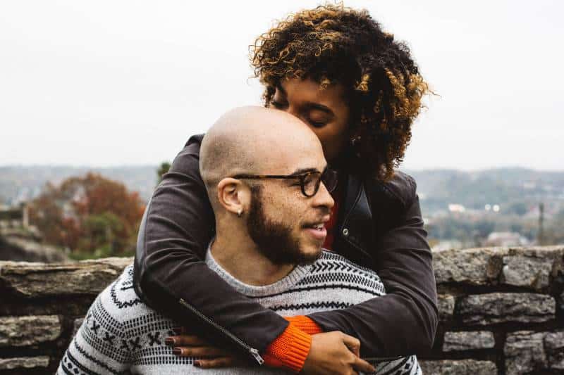 fille embrassant la tête d'un homme