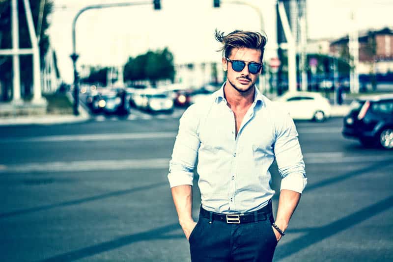 homme de mode portant des lunettes de soleil et une chemise blanche dans la rue