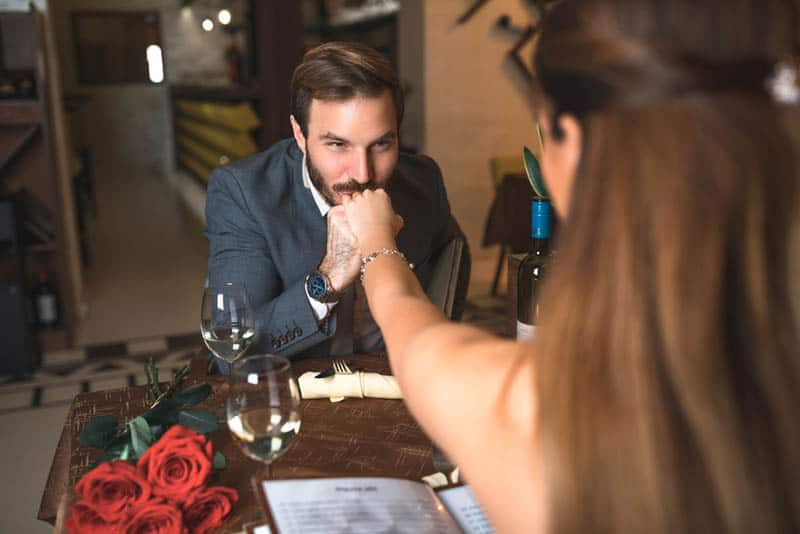 homme embrassant la main d'une femme lors d'un rendez-vous