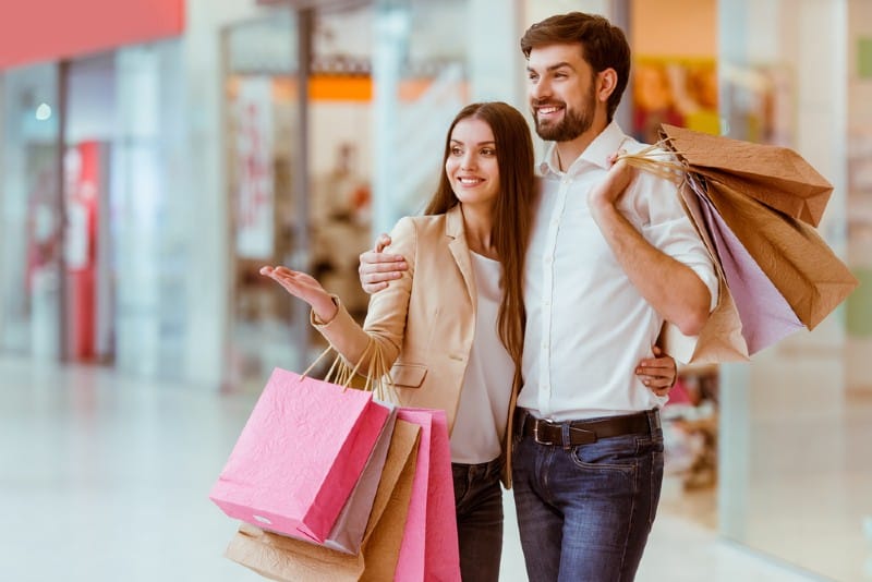 homme et femme heureux font du shopping au centre commercial