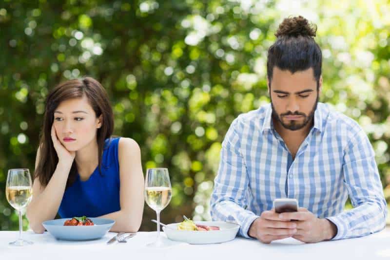 homme ignorant sa petite amie et utilisant le téléphone