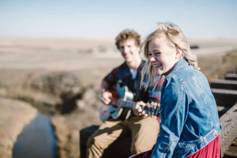 homme jouant de la guitare à côté d'une fille souriante