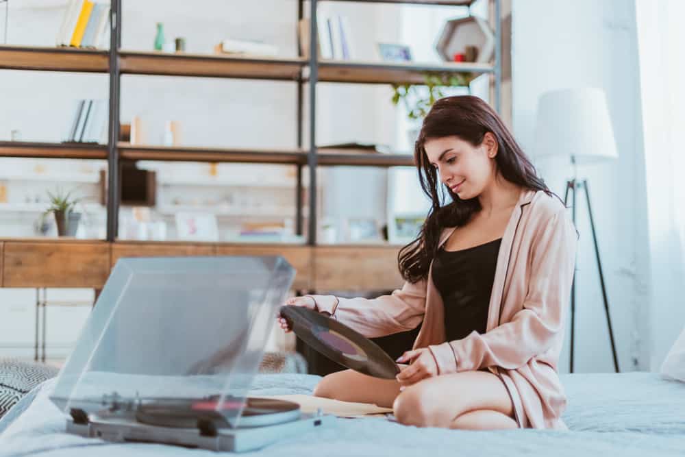 la femme est assise dans son lit, tenant une planche à la main