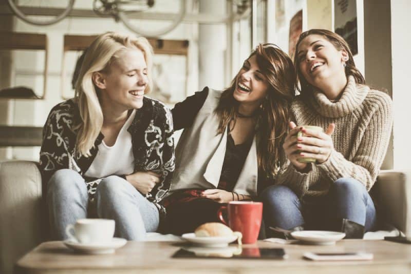 les filles qui s'amusent à la maison et boivent un thé