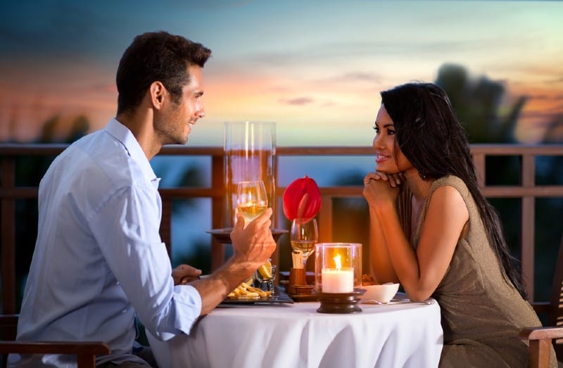 homme et femme rendez-vous romantique à une table au bord de la mer